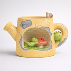 Yellow watering can planter with cute frog figurines, mushroom, snail, and 'sweet' text