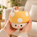 Cute yellow mushroom-shaped ceramic planter with a sleeping cat figurine, held in hands indoors