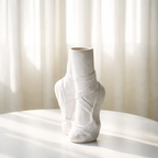 White ceramic vase on a white surface with a light background