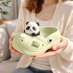Woman holding green clog-shaped container with cute panda figurine, Germiant home decor