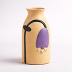 Beige vase with purple and black design on a white background