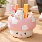 Cute pink mushroom-shaped pen holder with cartoon rabbit design on a wooden surface.