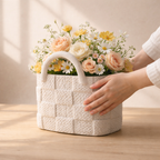 White textured basket filled with flowers on a wooden surface