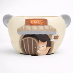 Cute bear-shaped ceramic mug with a cat at a cafe door, novelty drinkware from Germiant