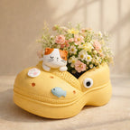 Yellow clog shoe flower pot with cat decoration, daisies, and pink roses, Germiant decor