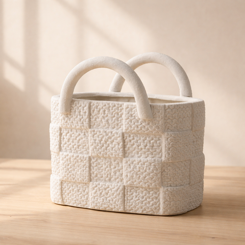 Textured ceramic basket with handles on a wooden surface