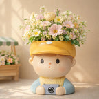 Cute ceramic boy planter with yellow cap, filled with pastel flowers on tabletop, Germiant