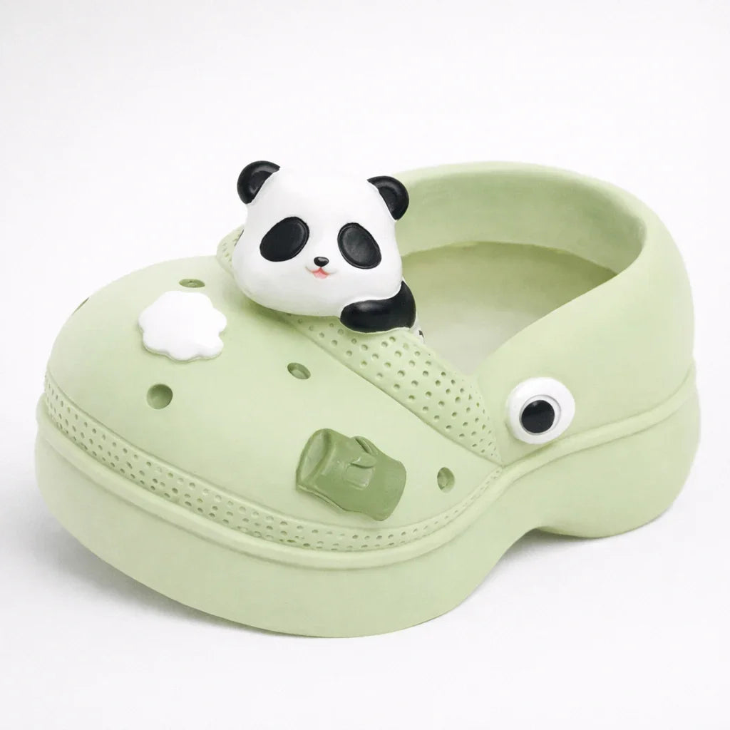 Light green clog shoe with panda and decorative charms on white background, Germiant