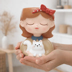 Decorative figurine of a girl with a cat held in hands against a blurred indoor background