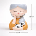 Decorative figurine of a girl with gray hair holding a dog, with measurements indicated.