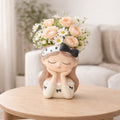Ceramic girl head planter with peach roses and daisies on a wooden table, Germiant decor