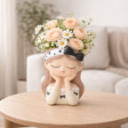 Ceramic girl head planter with peach roses and daisies on a wooden table, Germiant decor