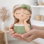 Hand holding a cute girl figurine with green dress and polka dot bow, Germiant decor