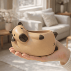 Person holding a cute capybara-shaped pot in a living room setting
