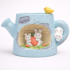 Cute blue watering can planter with bunny figurines and a carrot, Germiant home decor