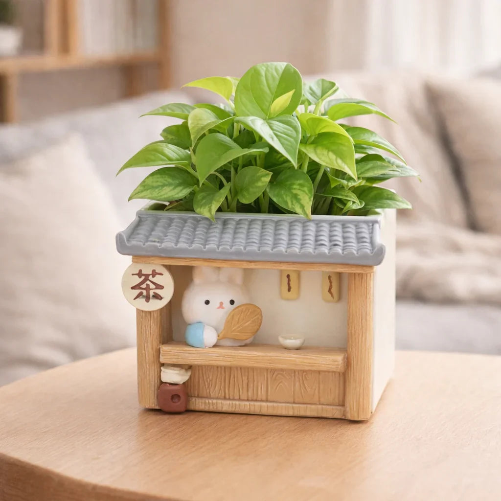 Cute bunny ceramic planter with green houseplant, tea shop design, on table, Germiant