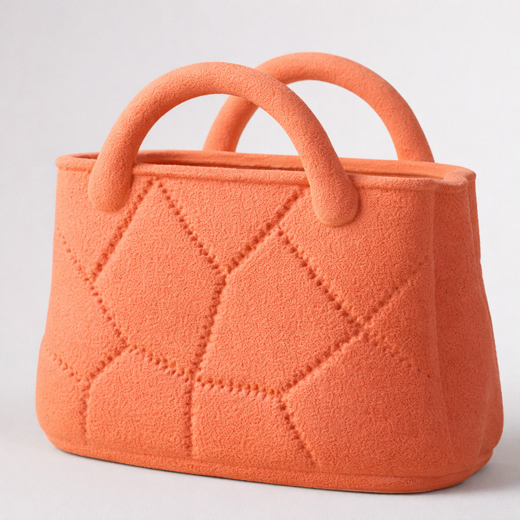 Orange quilted handbag on a light gray background