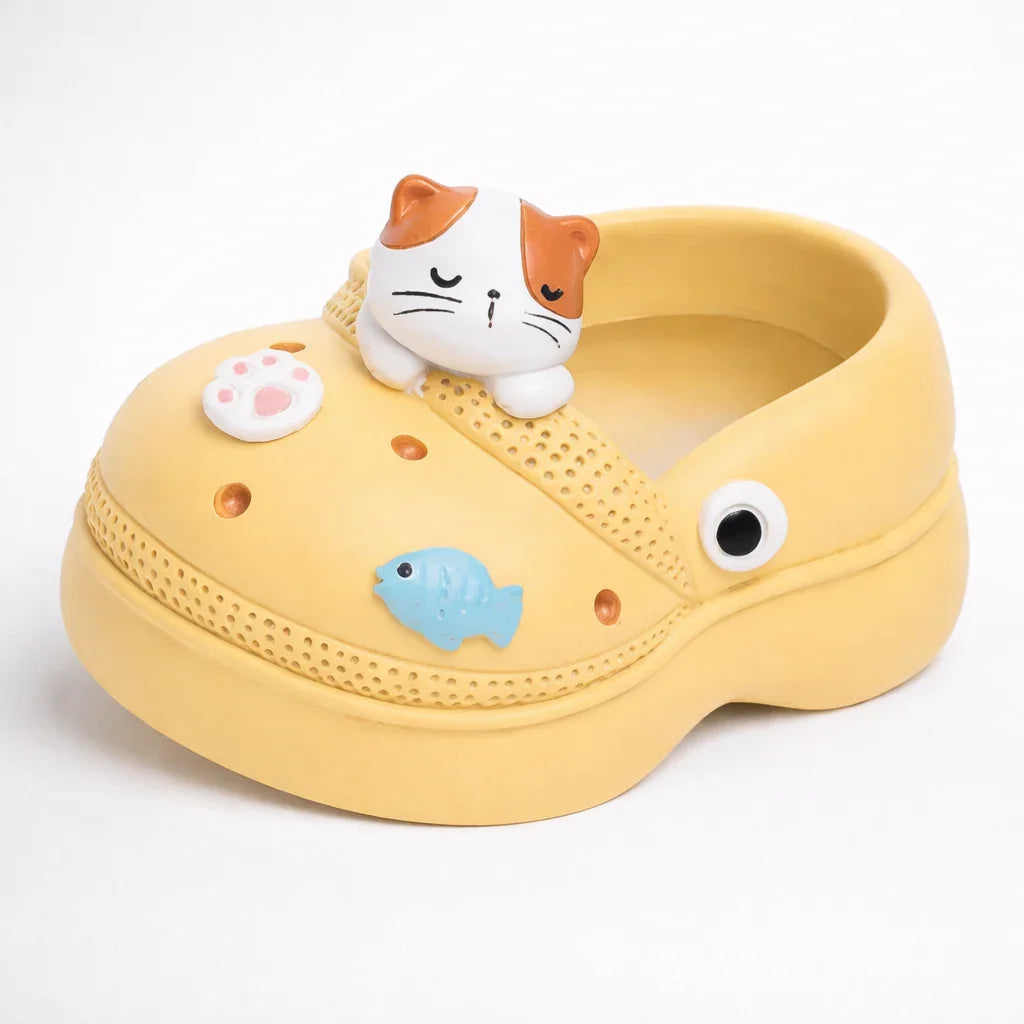 Yellow Germiant shoe with cute cat, paw, fish, and eye decorations on white background.